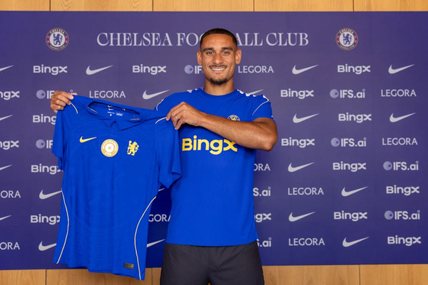 Maxence Lacroix holding a Chelsea shirt after signing in 2026